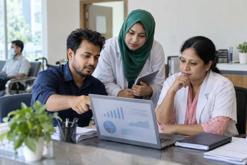 Clinic team reviewing website reports together at reception Clinic team reviewing website reports together at reception